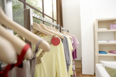 Kıyafetler moda mağaza ahşap askı üzerinde asılı.
