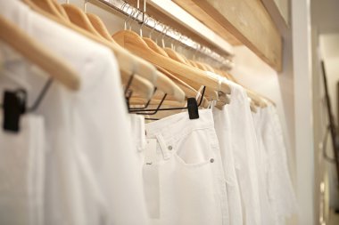 bir moda mağaza ahşap askı asılı beyaz elbise detay.