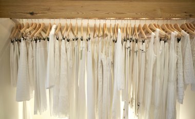 beyaz elbiseler moda mağaza ahşap askı üzerinde asılı bir satýr.