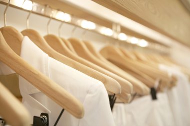 bir moda mağaza ahşap askı asılı beyaz elbise detay.