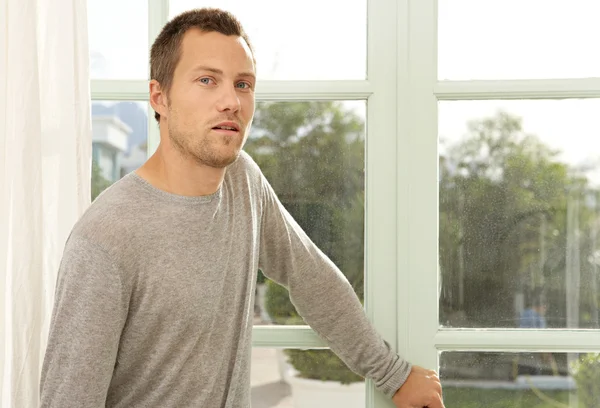 Hombre de pie junto a las puertas del jardín en casa . — Foto de Stock