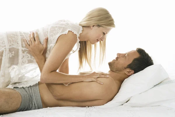 Casal jovem sendo afetuoso na cama . Imagens Royalty-Free