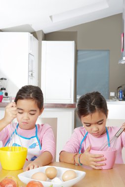 tatil yaparken üzerinde kendi ev mutfak yumurta atan iki özdeş ikiz kız kardeşi.