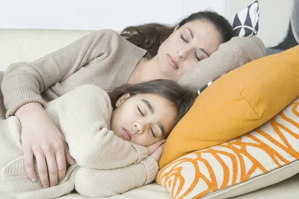 Young mum and daughter sleeping on a sofa at home. — Zdjęcie stockowe