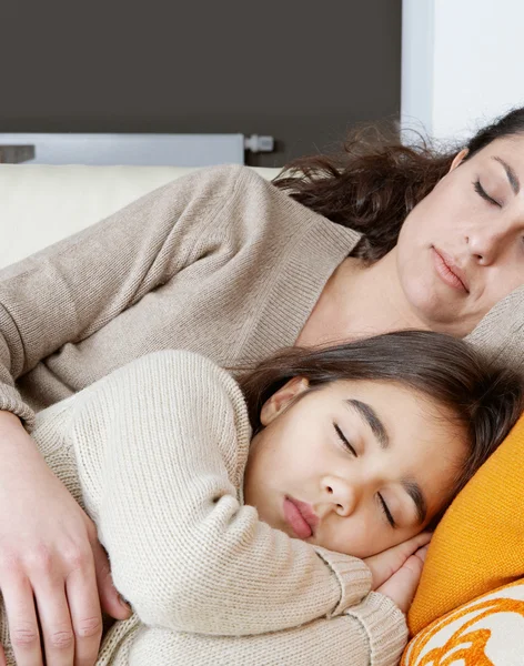 Matka a dcera spí na bílé kožené pohovce doma. — Stock fotografie