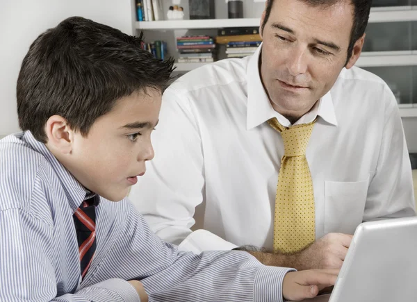 Padre e hijo trabajando en una computadora . — Foto de Stock