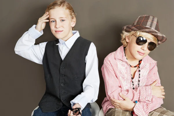 Two young brothers sitting together showing attitude and different personalities. — Stock Photo, Image