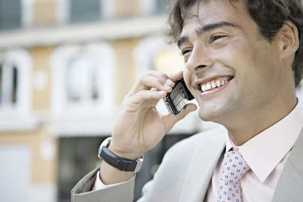 Jonge zakenman praten op een mobiele telefoon in de stad. — Stockfoto