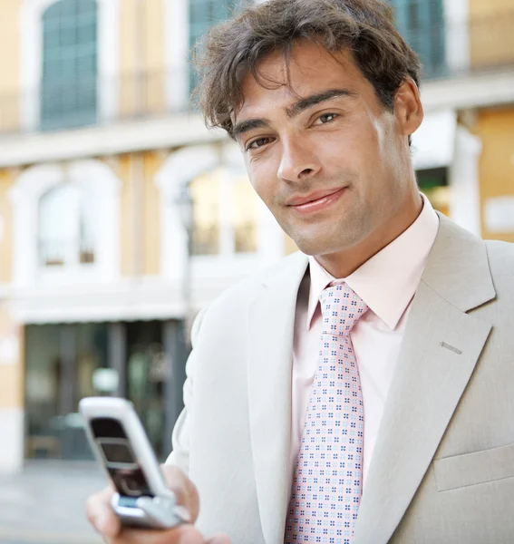 Young attractive businessman in a European city with classic office buildings in the background — Stock Photo, Image