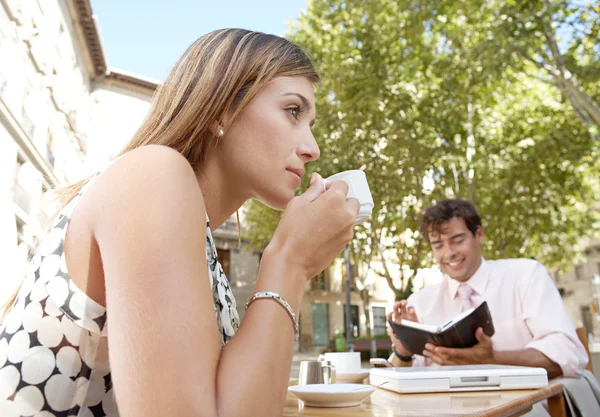 Affaires prendre un café assis à une table de café dans une place de la ville . — Photo