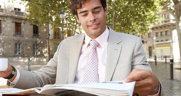 Hombre de negocios leyendo el periódico tomando café en una cafetería terraza —  Fotos de Stock