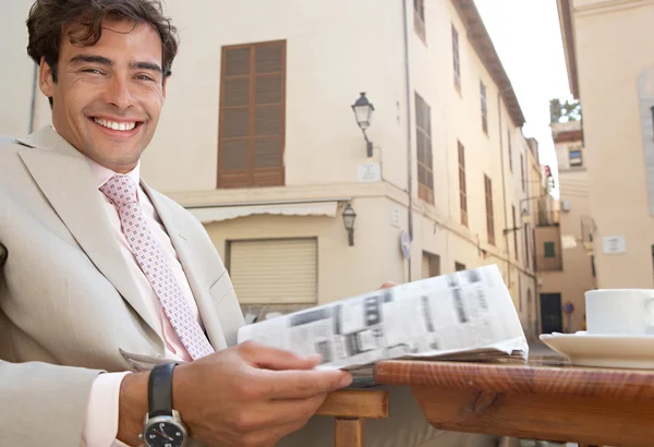 Empresario leyendo el periódico mientras toma un café en la terraza de una cafetería . —  Fotos de Stock