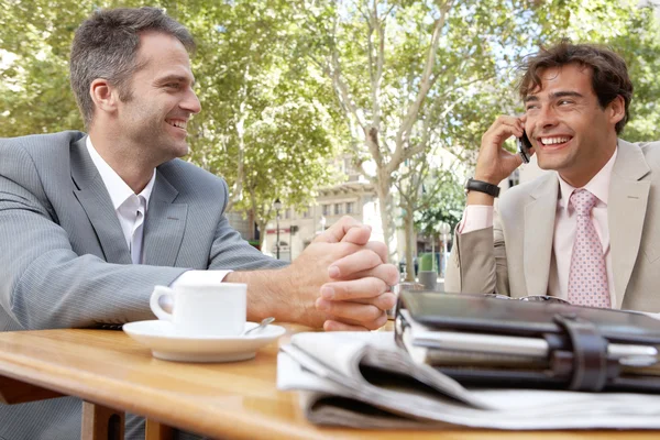 Two businessmen having a meeting in a coffee shop terrace outdoors. — Stock Photo, Image