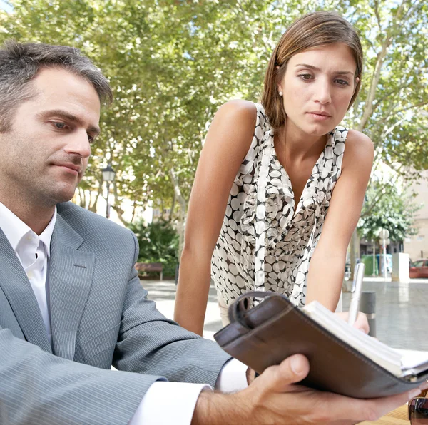 Zakenman en zakenvrouw met een bijeenkomst in een koffieshop terras buiten. — Stockfoto