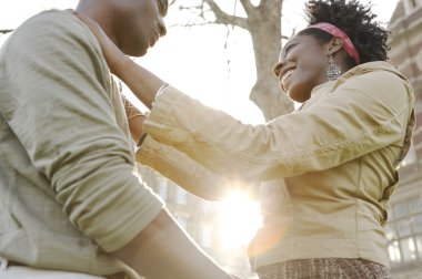 Genç çiftin birbirlerini bedenlerini filtreleme günbatımı güneş ile şehirde holding.
