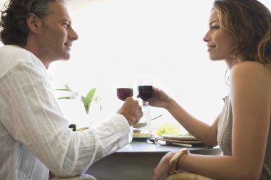 Olgun çift otelde öğle yemeği yerken kırmızı şarap ile kızartma.