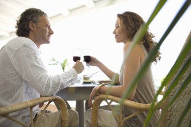 Olgun çift otelde öğle yemeği yerken kırmızı şarap ile kızartma.