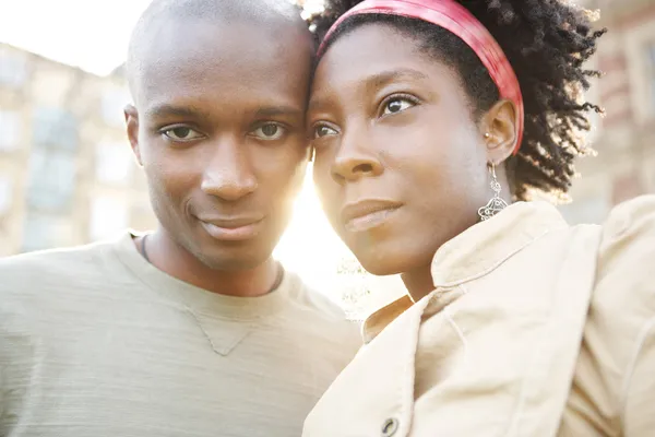 Retrato de um jovem casal negro de turistas que visitam a cidade ao pôr do sol — Fotografia de Stock