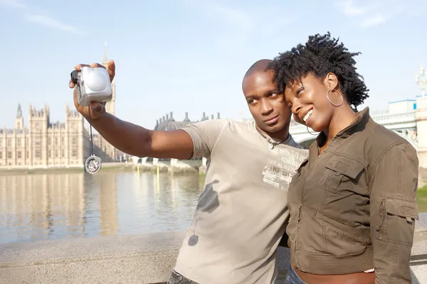 African american couple taking pictures of themselves while on vacations in London — Stock Photo, Image