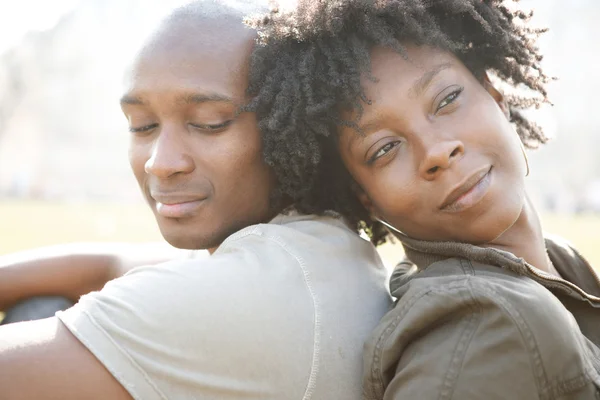 Young african american couple sitting back to back while visiting London on vacation — Stock Photo, Image