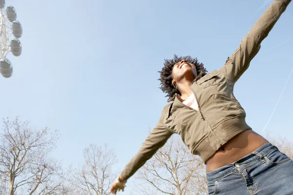 Black woman with her arms outstretched against the blue sky in London city — Stock Photo, Image