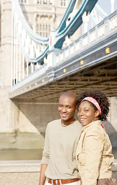 Attractive african american couple walking passed Tower Bridge in London — Stock Photo, Image