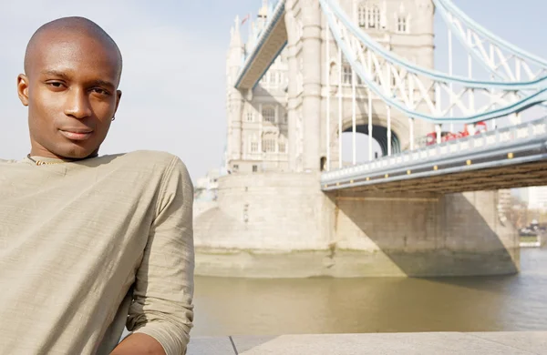 Привабливі афро-американських чоловік, що стоїть за Тауерський міст у Лондоні — стокове фото