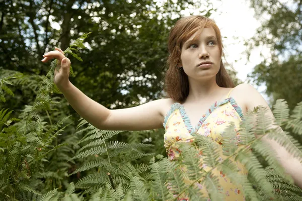 Teenage girl walking through fern foliage. — Stock Photo, Image