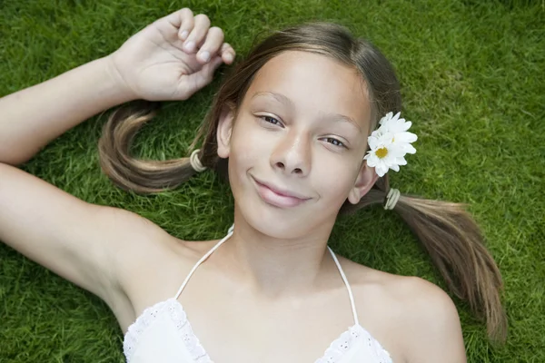 Retrato de menina adolescente que estabelece na grama . — Fotografia de Stock