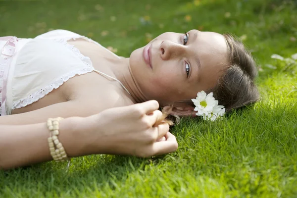 Vue latérale de l'adolescente allongée sur l'herbe . — Photo