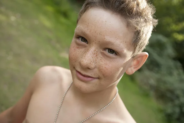 Close up portrait of teenage boy smiling at camera, outdoors. — Stock Photo, Image