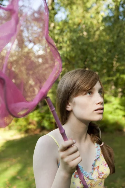 Teenage girl holding a butterfly net in the forest. — Stock Photo, Image