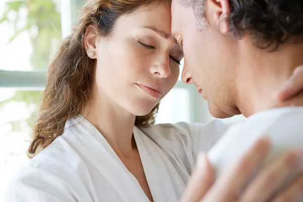 Nahaufnahme eines reifen Paares, das sich zu Hause umarmt, die Köpfe zusammen. — Stockfoto