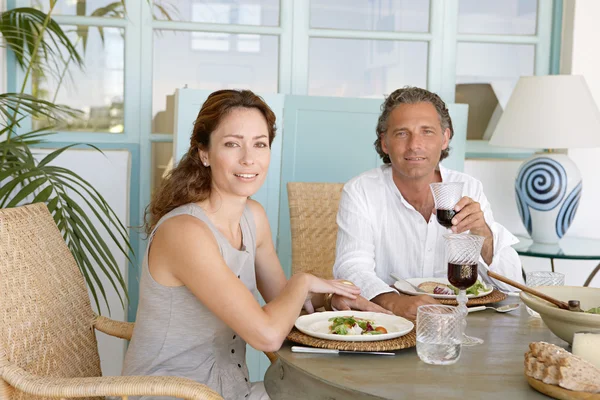 Olgun çift yemek ve birlikte Bahçe masada, kameraya gülümseyen içme.