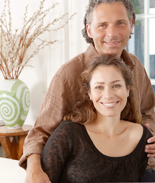 Retrato de una pareja madura descansando en un sofá blanco en casa . —  Fotos de Stock