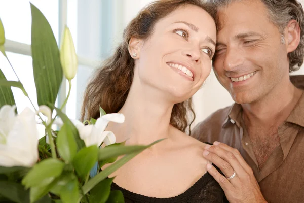 Close up of a mature couple with bunch of flowers at home. Royalty Free Stock Images