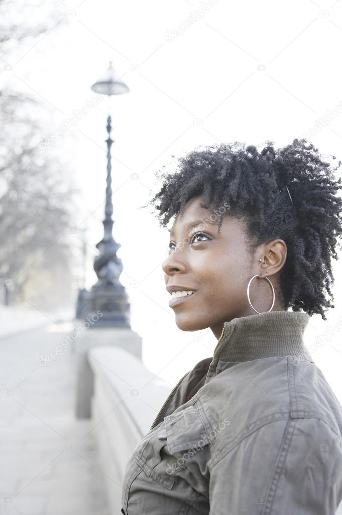 Portrait of a young african american woman in London's Thames river bank.