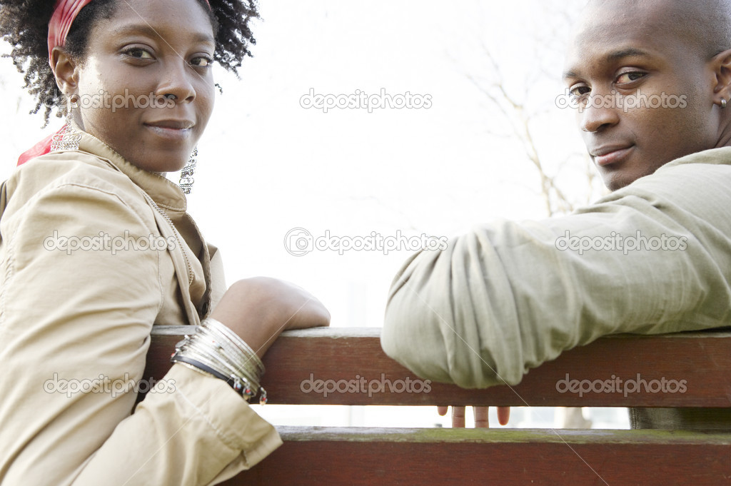 Young couple sitting on a wooden bench