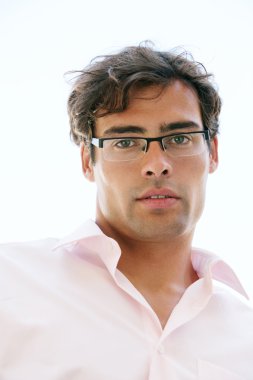 gözlük takan ve kameraya bakarak çekici işadamı