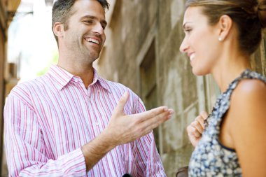 Businessman and businesswoman having an animated conversation outdoors
