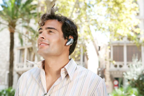 Businessman using a hands free device to have a conversation on his cell phone — Stock Photo, Image