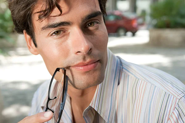 Atraktivní podnikatel brýle a při pohledu na fotoaparát, usmíval se ve městě — Stock fotografie