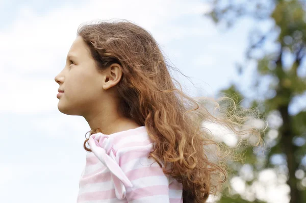 Seitenansicht eines jungen Mädchens, das in den Park blickt — Stockfoto