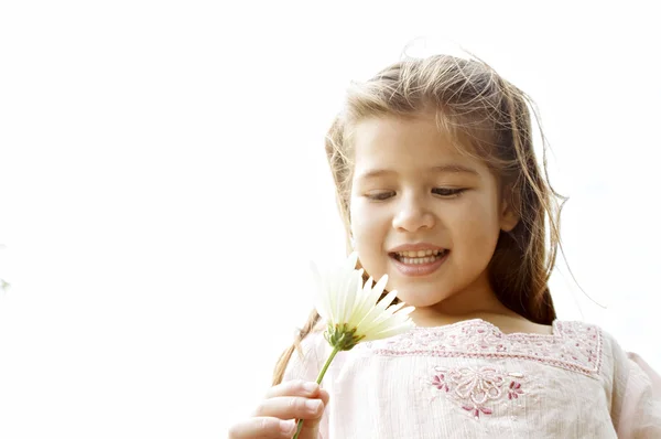 Giovane ragazza che tiene un fiore margherita contro il cielo . — Foto Stock