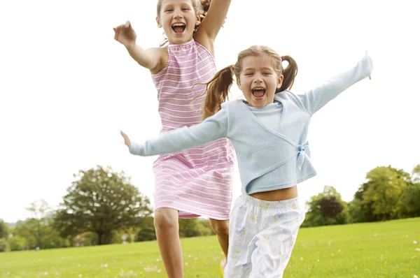 Zwei Mädchen laufen im Park auf die Kamera zu. — Stockfoto