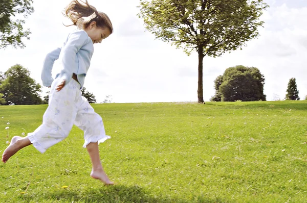 어린 아이 공원의 푸른 잔디에 점프. — 스톡 사진