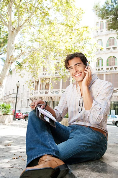Businessman using a hands free device to make a call on his cell phone Stock Photo