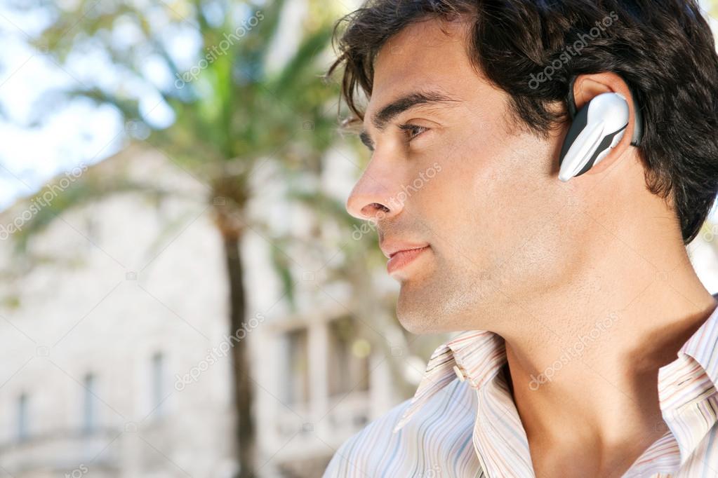 young attractive businessman using a hands free device to have a conversation on his cell phone