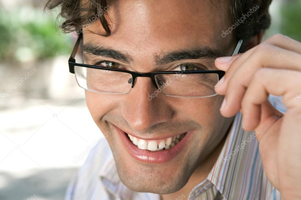 attractive businessman wearing glasses and looking at the camera smiling