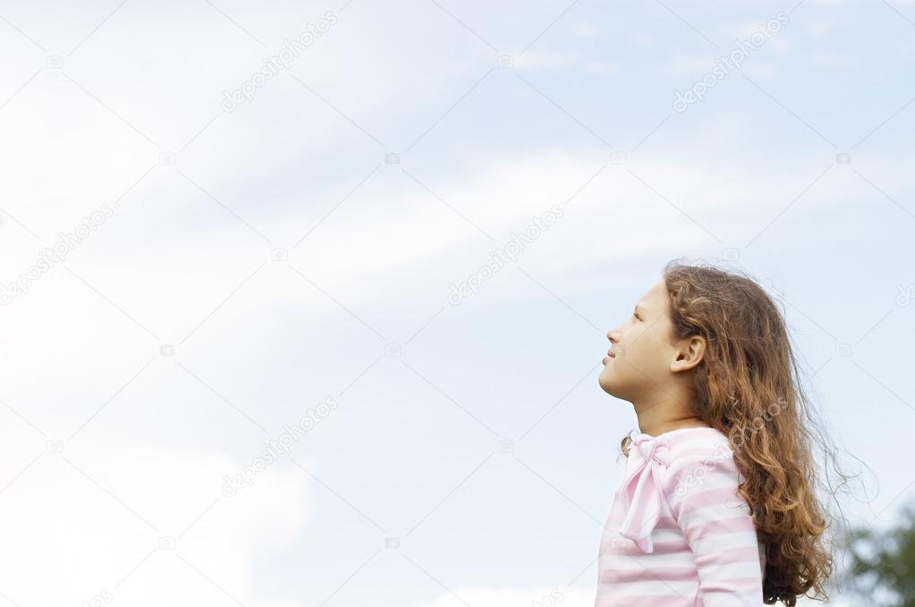 Side view of a young girl looking ahead in the park